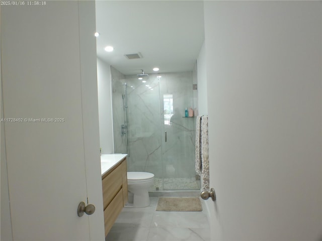 bathroom with a shower with door, vanity, and toilet