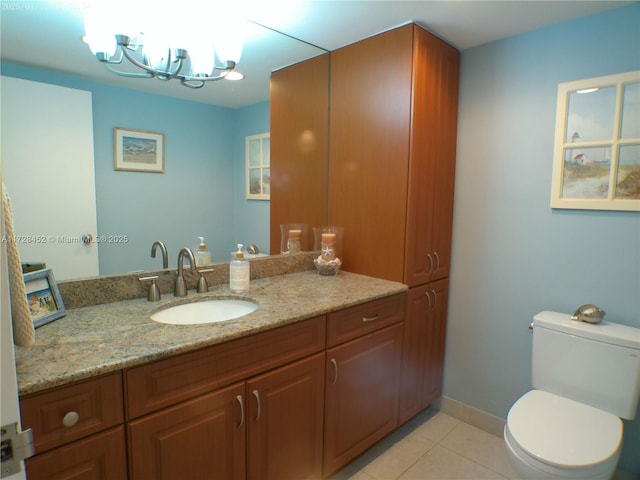 bathroom featuring vanity, toilet, tile patterned flooring, and a notable chandelier