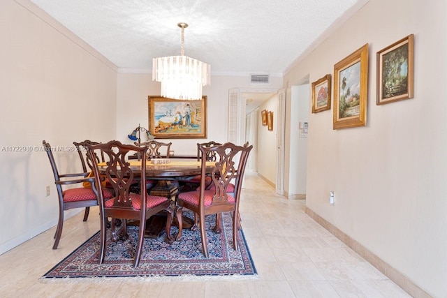 dining area featuring a textured ceiling, ornamental molding, and an inviting chandelier