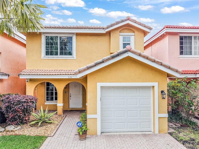 mediterranean / spanish-style house with a garage