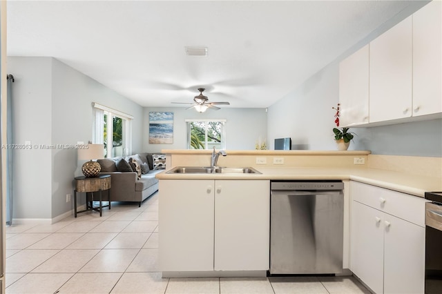 kitchen with sink, white cabinetry, light tile patterned floors, stainless steel dishwasher, and kitchen peninsula