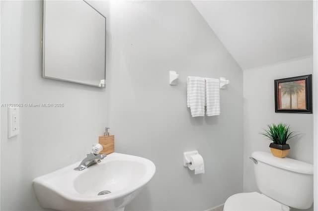 bathroom featuring vaulted ceiling, toilet, and sink