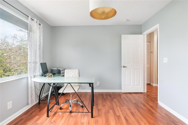 office with wood-type flooring and a textured ceiling