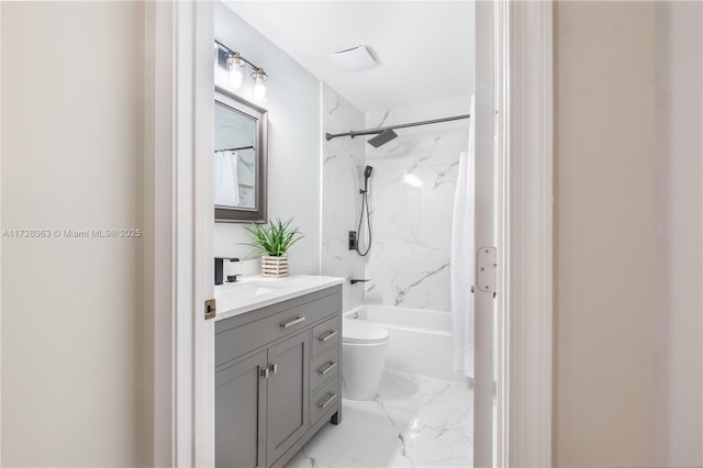 full bathroom featuring tiled shower / bath, vanity, and toilet