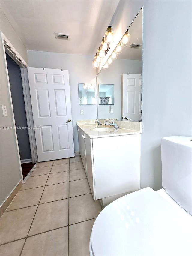 bathroom featuring vanity, tile patterned floors, and toilet