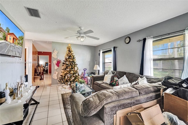 tiled living room with ceiling fan and a textured ceiling