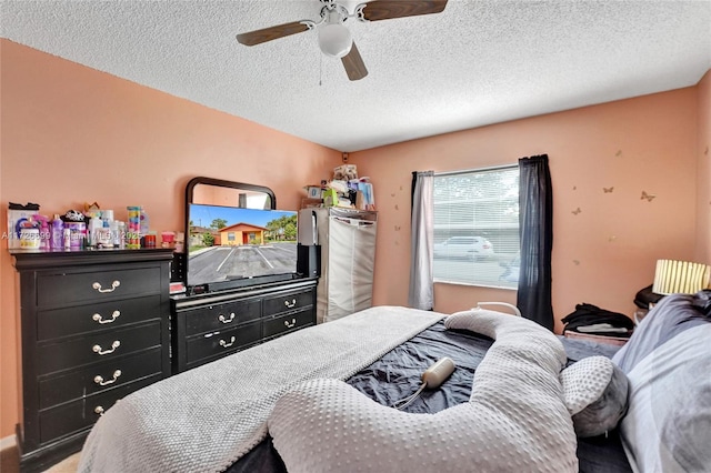 bedroom featuring ceiling fan and a textured ceiling