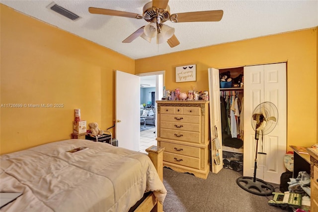 carpeted bedroom with a textured ceiling, a closet, and ceiling fan