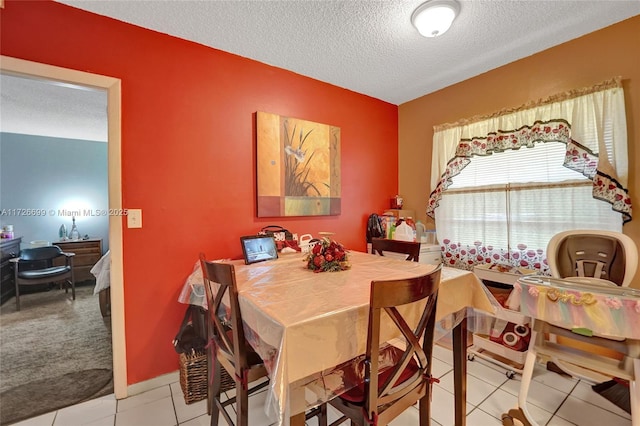 dining space featuring light tile patterned floors and a textured ceiling