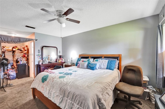 carpeted bedroom featuring ceiling fan and a textured ceiling