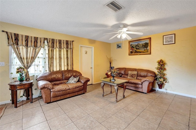 tiled living room featuring ceiling fan and a textured ceiling