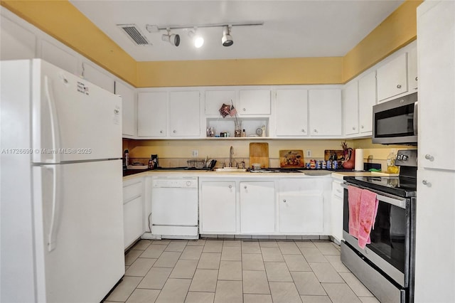 kitchen with light tile patterned floors, white cabinetry, appliances with stainless steel finishes, and sink