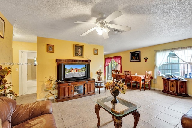 tiled living room featuring a textured ceiling and ceiling fan