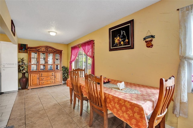 tiled dining room with a textured ceiling