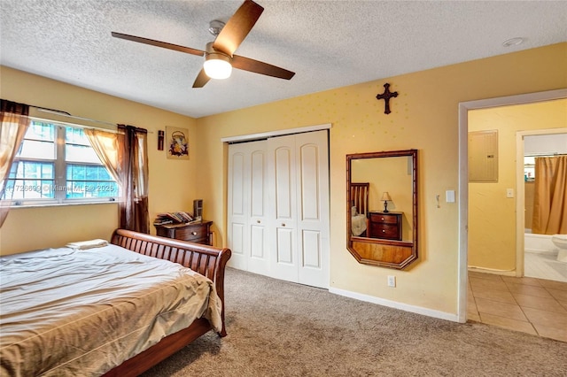 bedroom featuring ensuite bath, carpet floors, a closet, ceiling fan, and electric panel