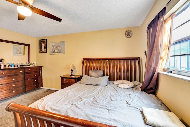 carpeted bedroom with a textured ceiling and ceiling fan