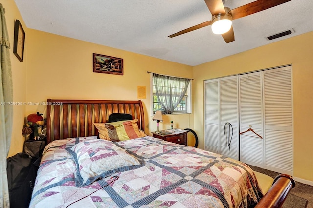 carpeted bedroom featuring ceiling fan, a textured ceiling, and a closet