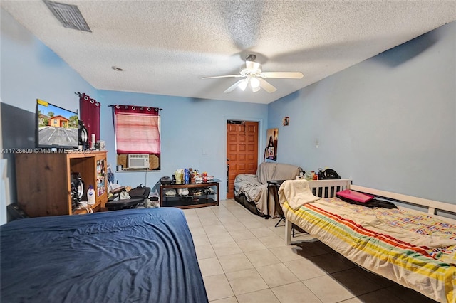 bedroom featuring light tile patterned flooring, a textured ceiling, cooling unit, and ceiling fan