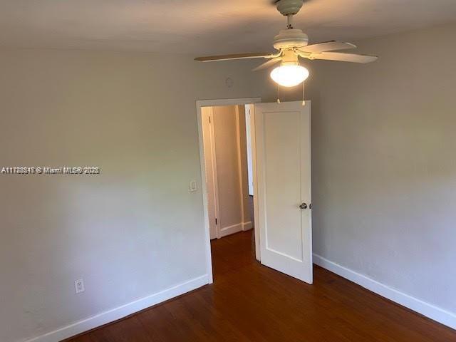 spare room featuring ceiling fan and dark hardwood / wood-style flooring