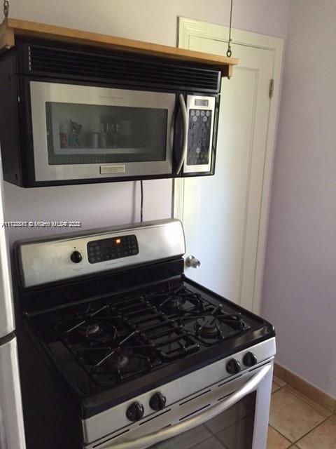 kitchen with light tile patterned floors and appliances with stainless steel finishes