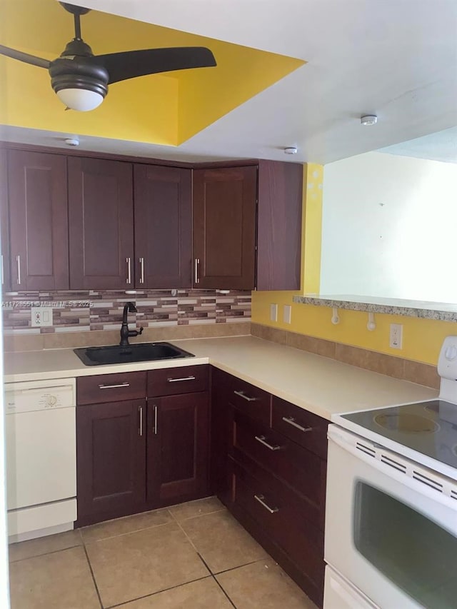 kitchen with sink, light tile patterned floors, backsplash, and white appliances