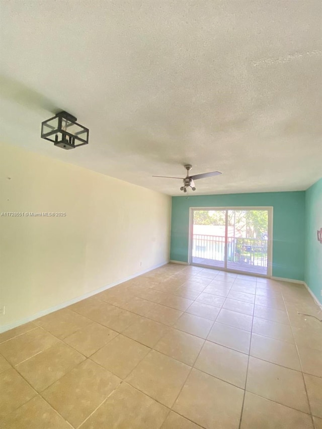 spare room with ceiling fan, a textured ceiling, and light tile patterned floors