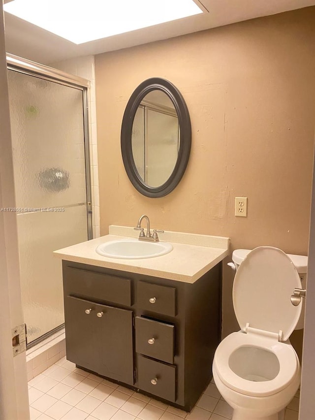 bathroom with an enclosed shower, vanity, tile patterned floors, and toilet