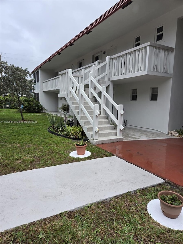 exterior space featuring a balcony, a yard, and a patio area