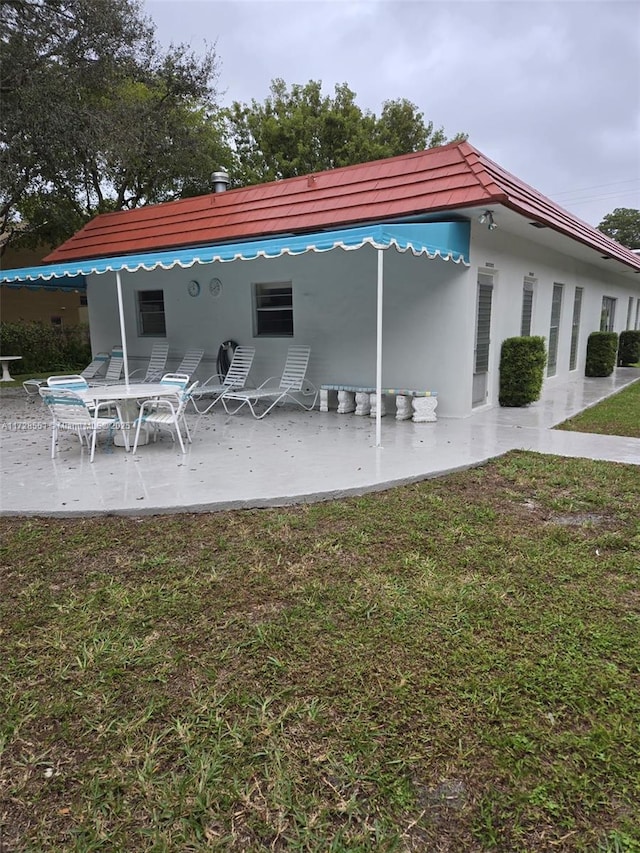 rear view of house with a patio area and a lawn