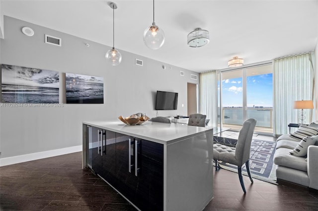 kitchen with pendant lighting, floor to ceiling windows, dark hardwood / wood-style floors, and a center island