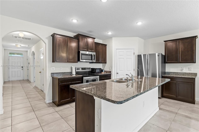 kitchen featuring an island with sink, sink, stainless steel appliances, and light tile patterned flooring