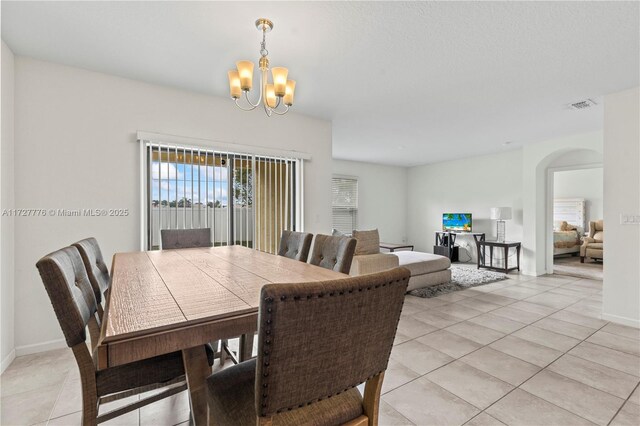 dining area featuring an inviting chandelier and light tile patterned floors