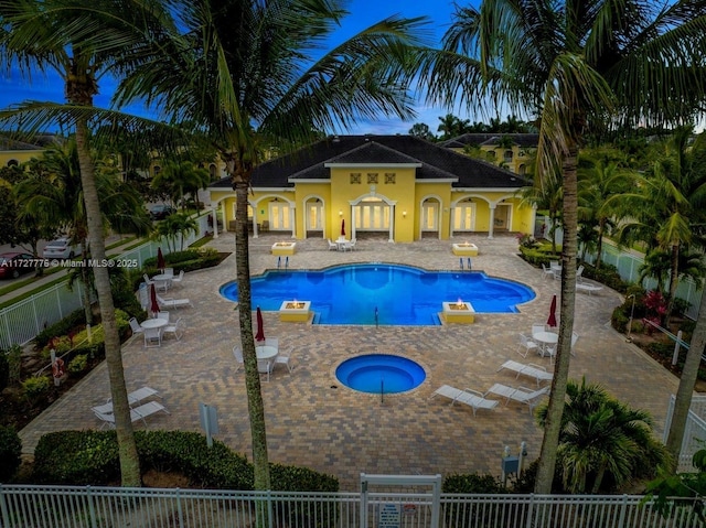 pool featuring fence, a community hot tub, and a patio area