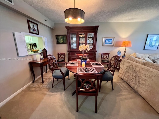 carpeted dining area featuring a textured ceiling