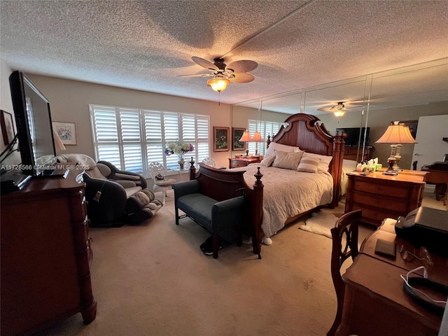 carpeted bedroom featuring a textured ceiling and ceiling fan