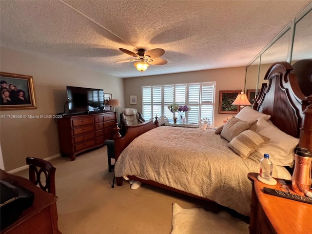 carpeted bedroom with ceiling fan and a textured ceiling