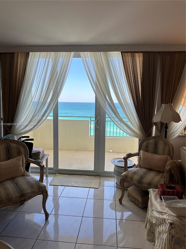 interior space featuring light tile patterned floors and a water view