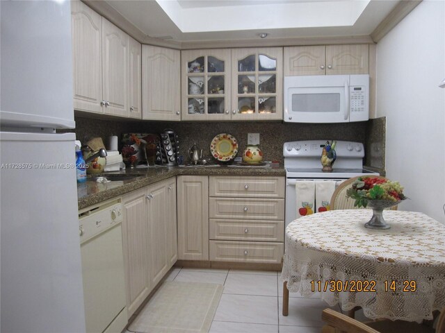 kitchen featuring decorative backsplash, sink, white appliances, and light tile patterned flooring