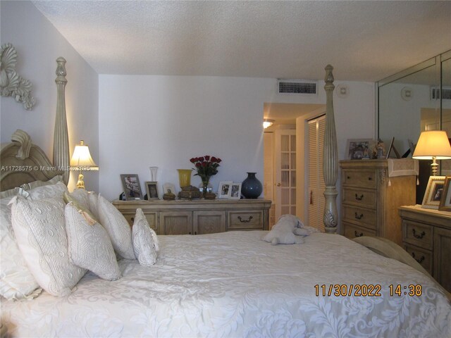 bedroom with a textured ceiling and a closet