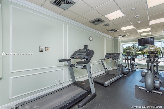 exercise room with a paneled ceiling and ornamental molding