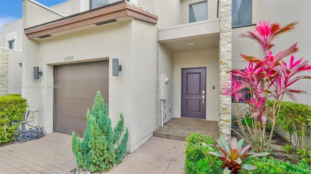 entrance to property featuring a garage and a balcony