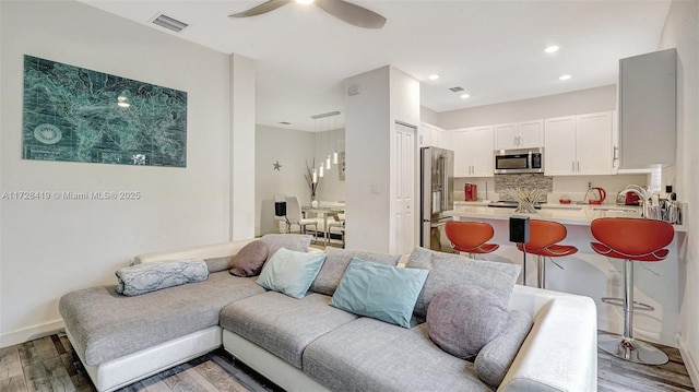 living room featuring ceiling fan and light hardwood / wood-style flooring