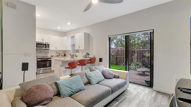 living room featuring light wood-type flooring and ceiling fan