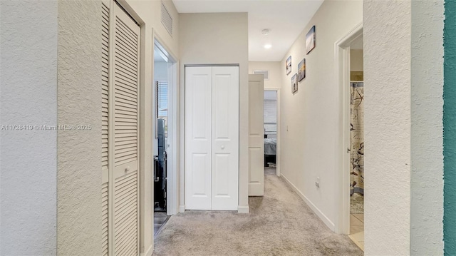 hall with light colored carpet