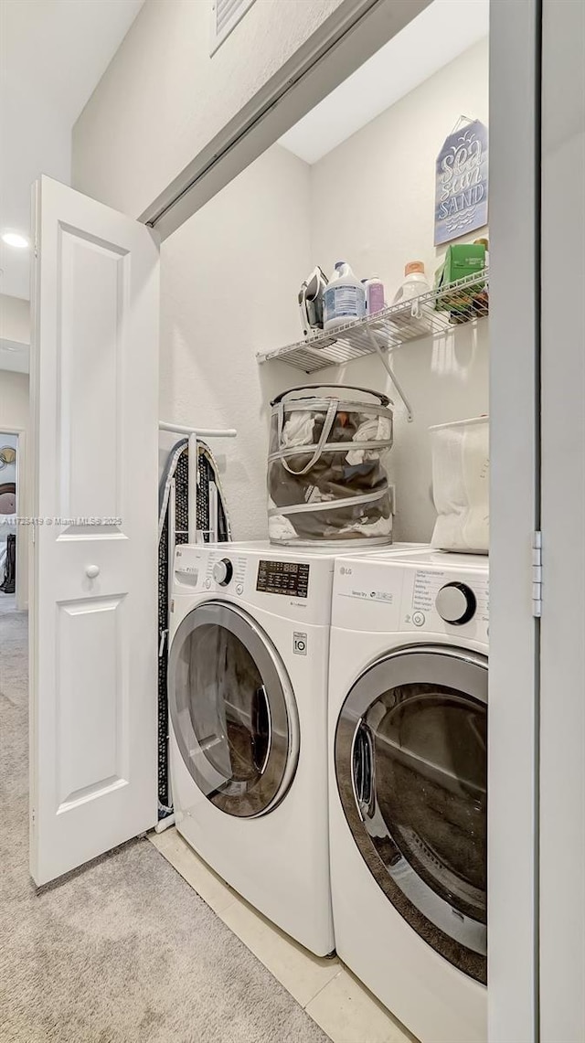 laundry room with light tile patterned floors and washing machine and dryer