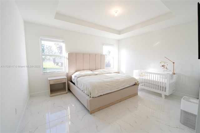 bedroom with a tray ceiling and radiator