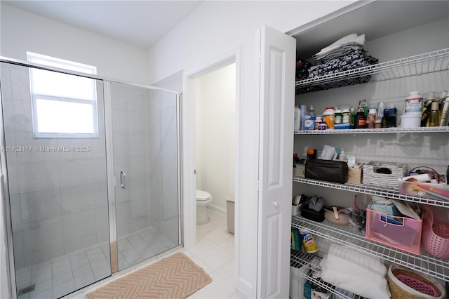 bathroom with walk in shower, tile patterned floors, and toilet