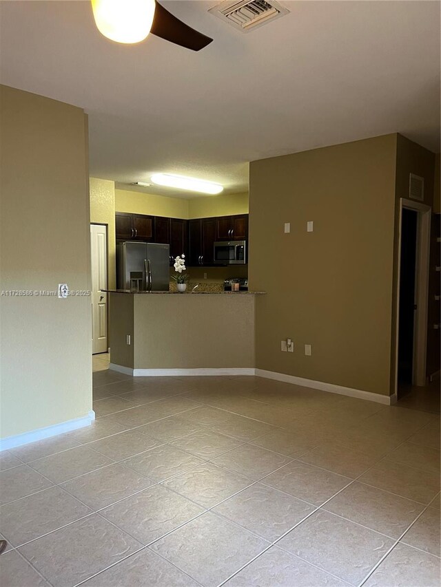 unfurnished living room featuring ceiling fan and light tile patterned floors