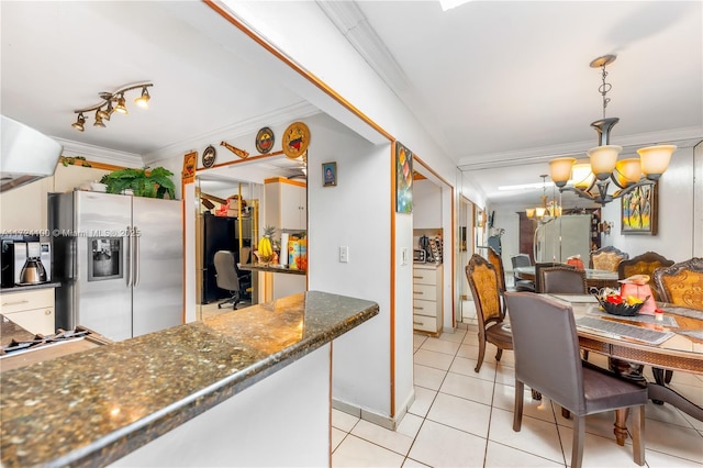 kitchen with pendant lighting, stainless steel refrigerator with ice dispenser, ornamental molding, a notable chandelier, and light tile patterned floors