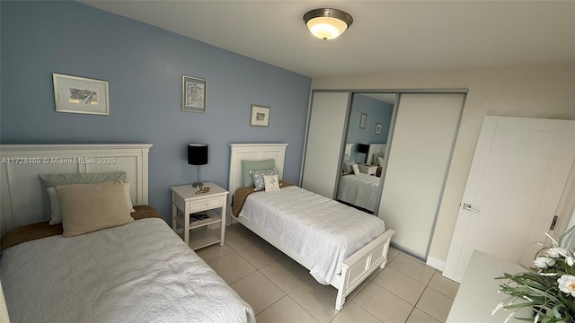 bedroom with light tile patterned floors and a closet